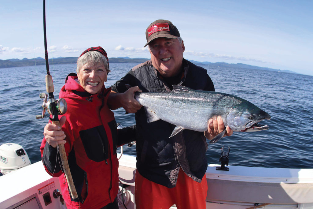 SSJ Saltwater Editor Tony Floor does the heavy lifting on this 14-pound coho caught by his wife Karyl. Below, a red label herring skewered and ready to fish.